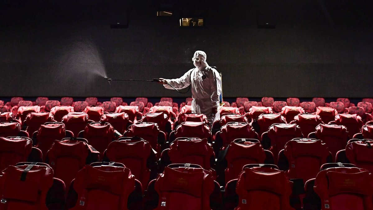 A Worker Sanitizing theater room for safety measure.